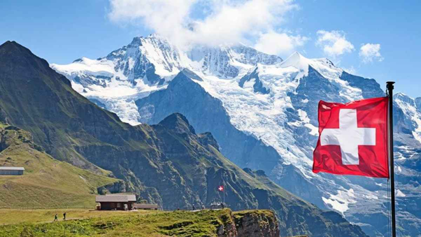 Imagen de portada que muestra los cerros de suiza y una bandera del país.